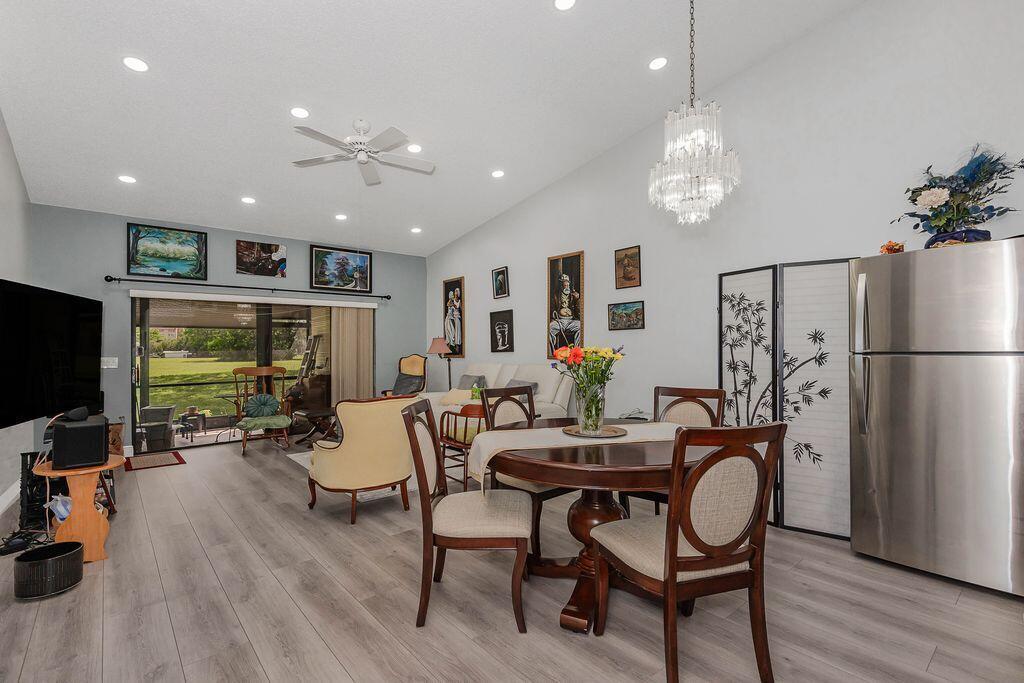 A dining area with a round table and chairs sits adjacent to a living room — 3459 Inverrary W # 3459, Lauderhill FL 33319, LAUDERHILL, FL