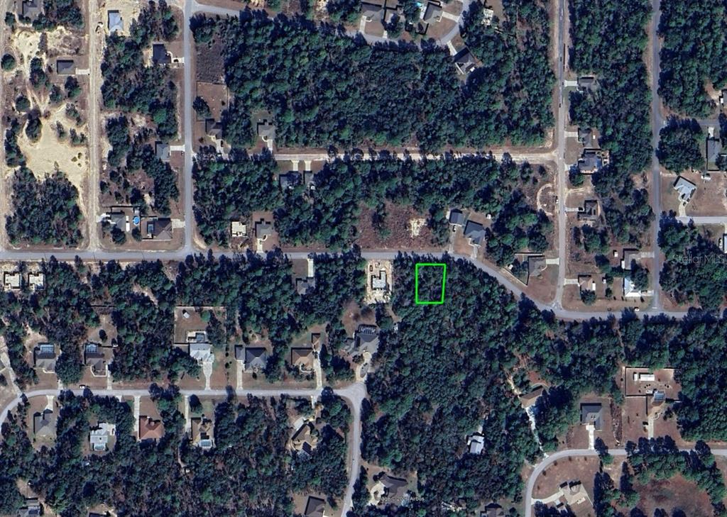 An aerial view shows a vacant, wooded residential lot outlined in green — 3012 W EUNICE DRIVE, DUNNELLON, FL