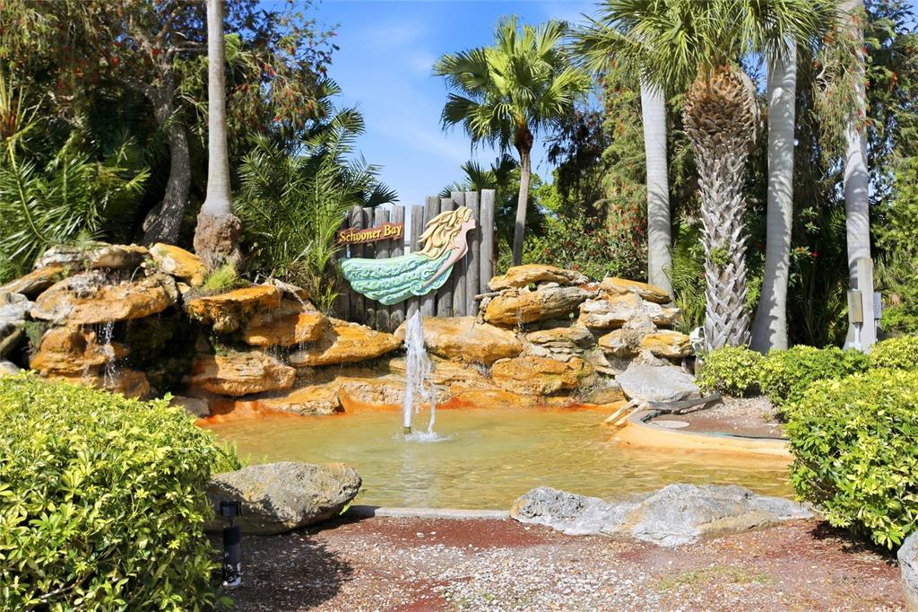 A small fountain sits in a pond in front of a Schooner Bay sign and rocks — 3460 N KEY DRIVE UNIT 407, NORTH FORT MYERS, FL