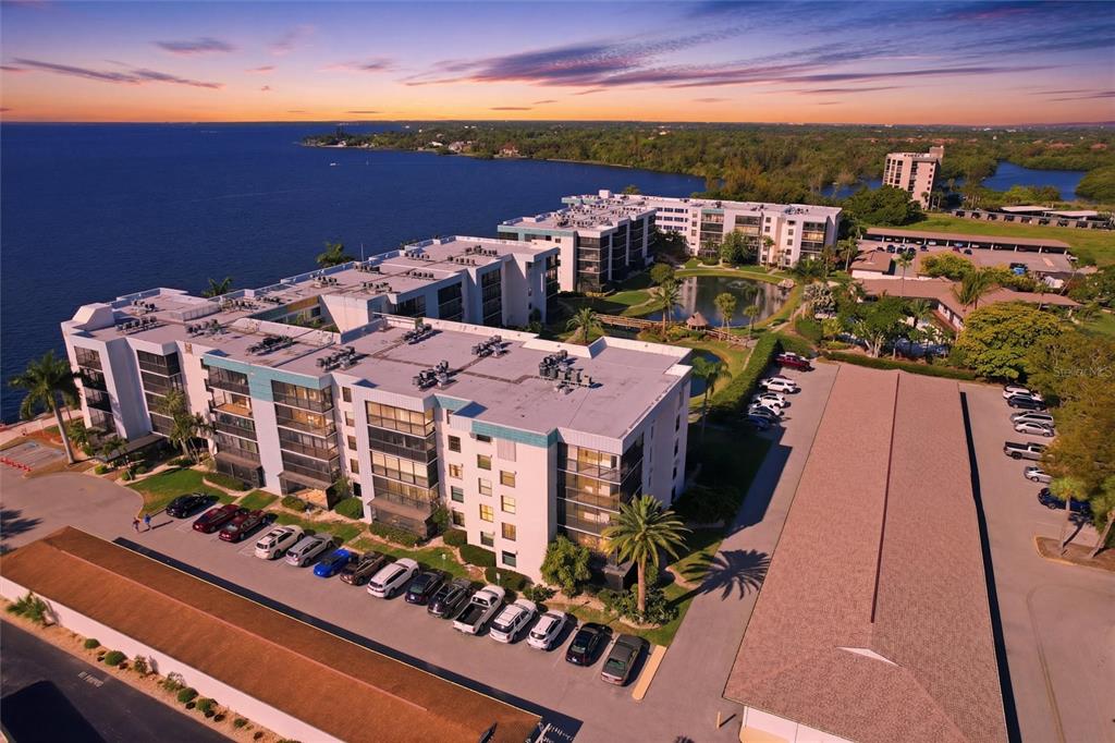 An aerial view of a waterfront apartment complex with a parking lot and pond — 3460 N KEY DRIVE UNIT 407, NORTH FORT MYERS, FL