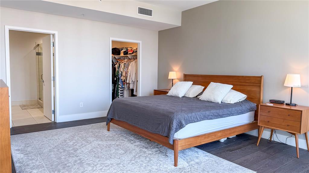 A bedroom features a wooden bed frame, a walk-in closet, and an attached bathroom — 175 1ST STREET S UNIT 1108, ST PETERSBURG, FL