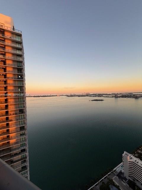 A high-angle view shows a tall residential building overlooking a large bay at sunset — 650 NE 32nd St # 4406, Miami FL 33137, MIAMI, FL