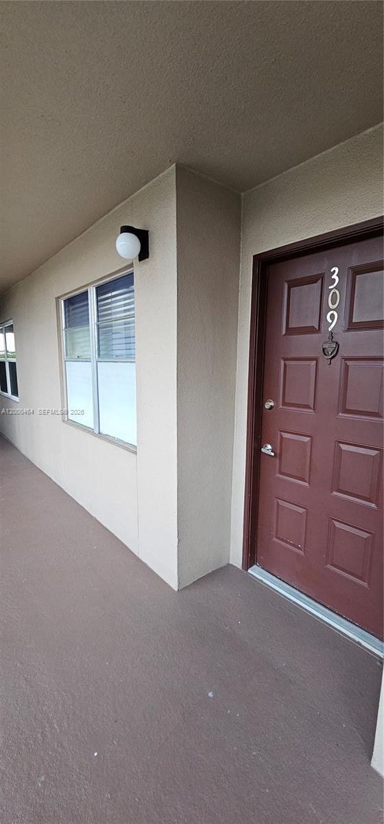 A brown front door with the number 309 is located on a covered exterior walkway — PEMBROKE PINES, FL