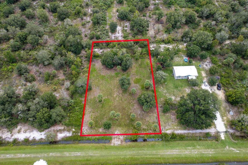 An aerial view shows a rectangular plot of land outlined in red near a house — 17128 NW 266TH STREET, OKEECHOBEE, FL