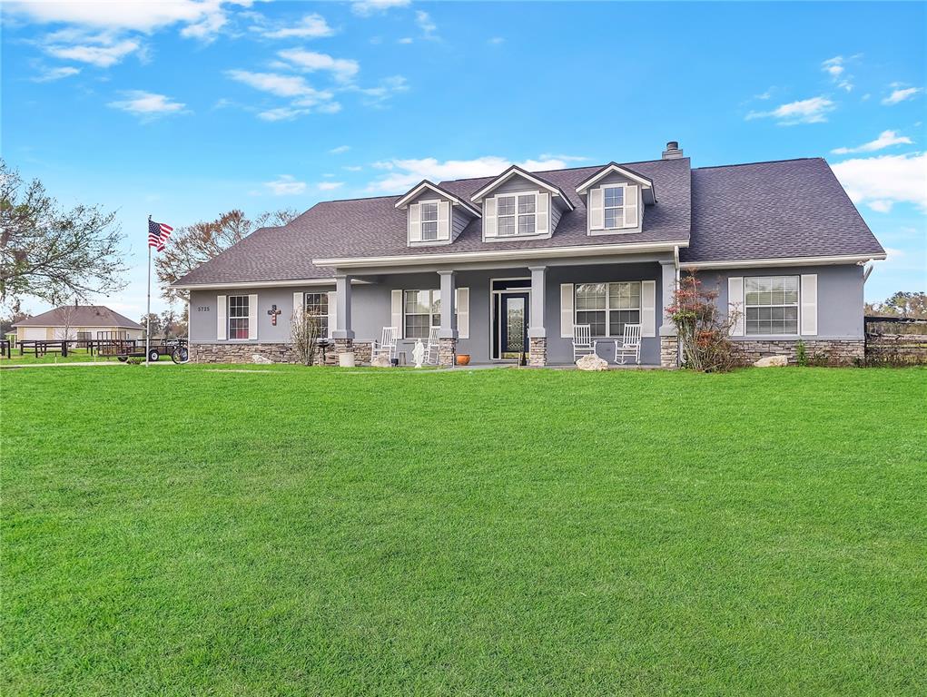 A gray single-story house with a stone base, dormer windows, and a front porch — 5725 NE 31ST TERRACE, OCALA, FL