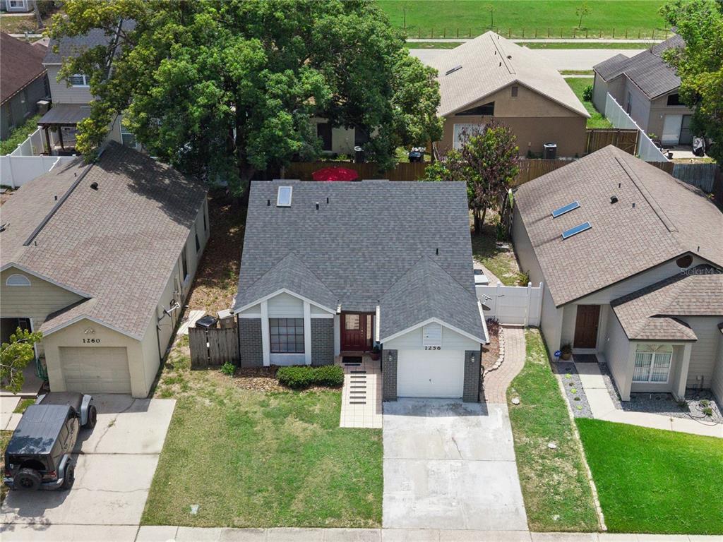 An aerial view shows a single-story house with a gray roof and a front garage — 1256 PIN OAK DRIVE, APOPKA, FL