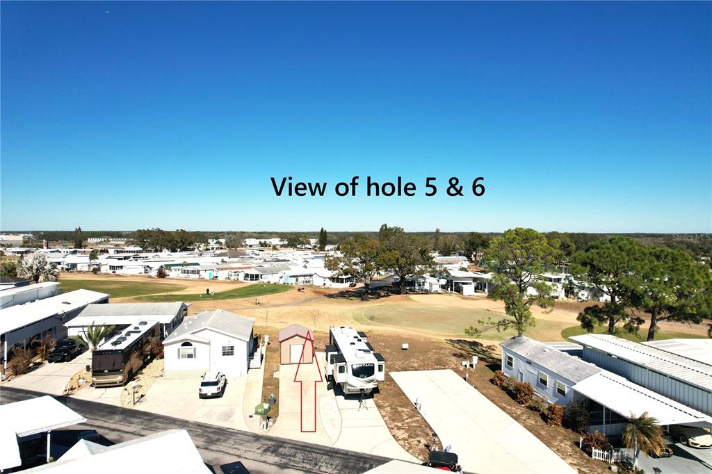 An aerial view shows a residential lot with a shed and RV overlooking a golf course — 328 ST GEORGE DRIVE, DAVENPORT, FL