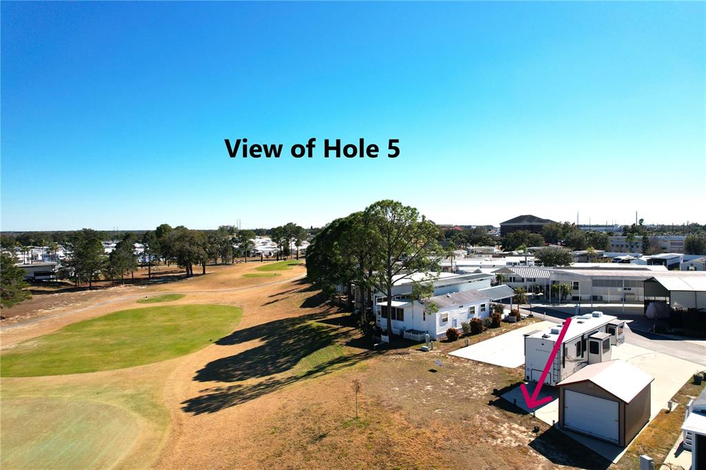 An aerial view shows a golf course hole adjacent to a residential lot with a trailer — 328 ST GEORGE DRIVE, DAVENPORT, FL