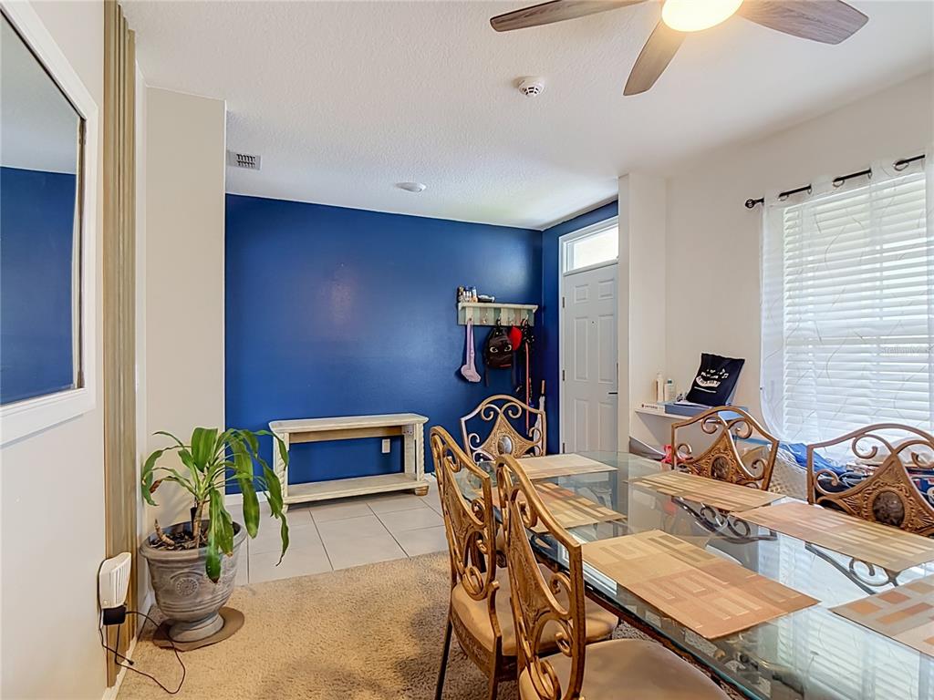 A dining room features a blue accent wall, a glass table, and tile flooring — 5911 SHINGLE CREEK ROAD, LAKELAND, FL