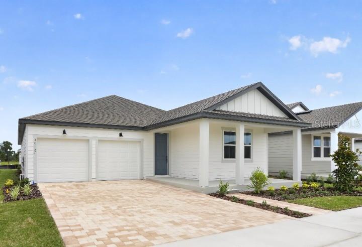 A single-story house with white siding, a two-car garage, and a paved driveway — 30157 MISTY PINES ROAD, MOUNT DORA, FL