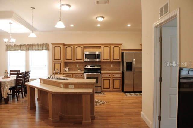 A kitchen features light wood cabinets, stainless steel appliances, and a central island with seating — 1759 NE 127TH STREET, BRANFORD, FL