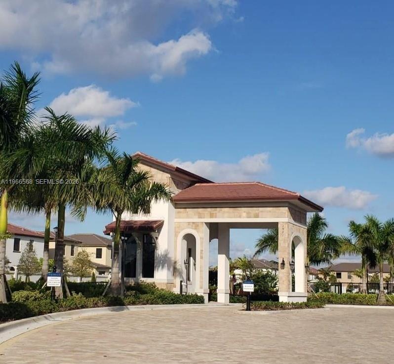 A stone-accented gatehouse entrance with a tiled roof stands at the community entry — 3350 W 112th St, Hialeah FL 33018, HIALEAH, FL