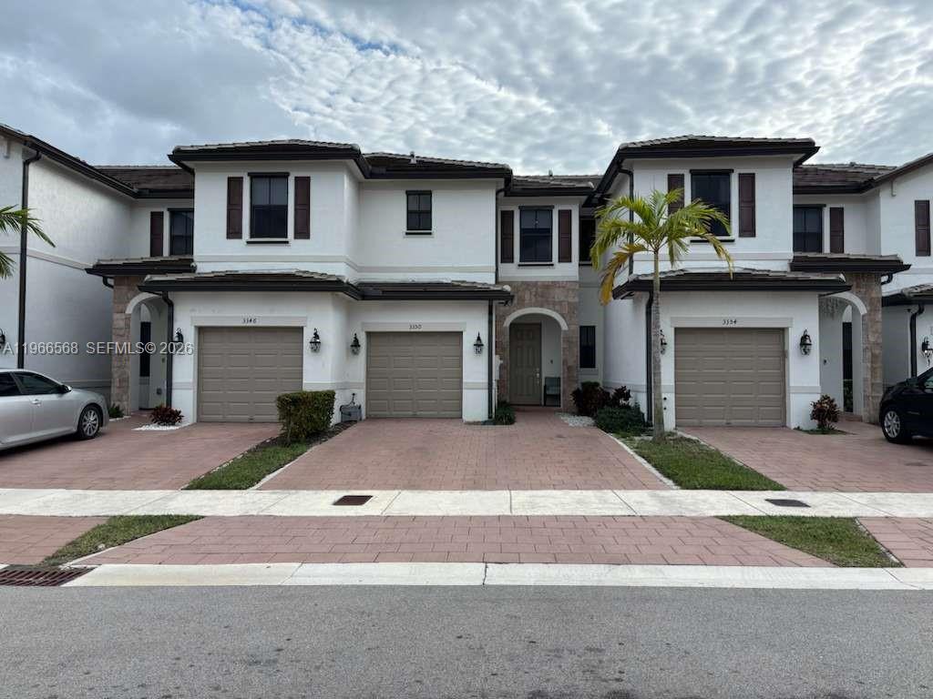 A row of three two-story townhomes with beige garages and white stucco exteriors — 3350 W 112th St, Hialeah FL 33018, HIALEAH, FL