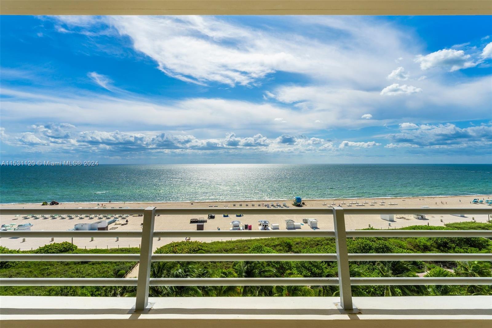A balcony with a metal railing overlooks a sandy beach and the ocean — 101 Ocean Dr # 907, Miami Beach FL 33139, MIAMI BEACH, FL