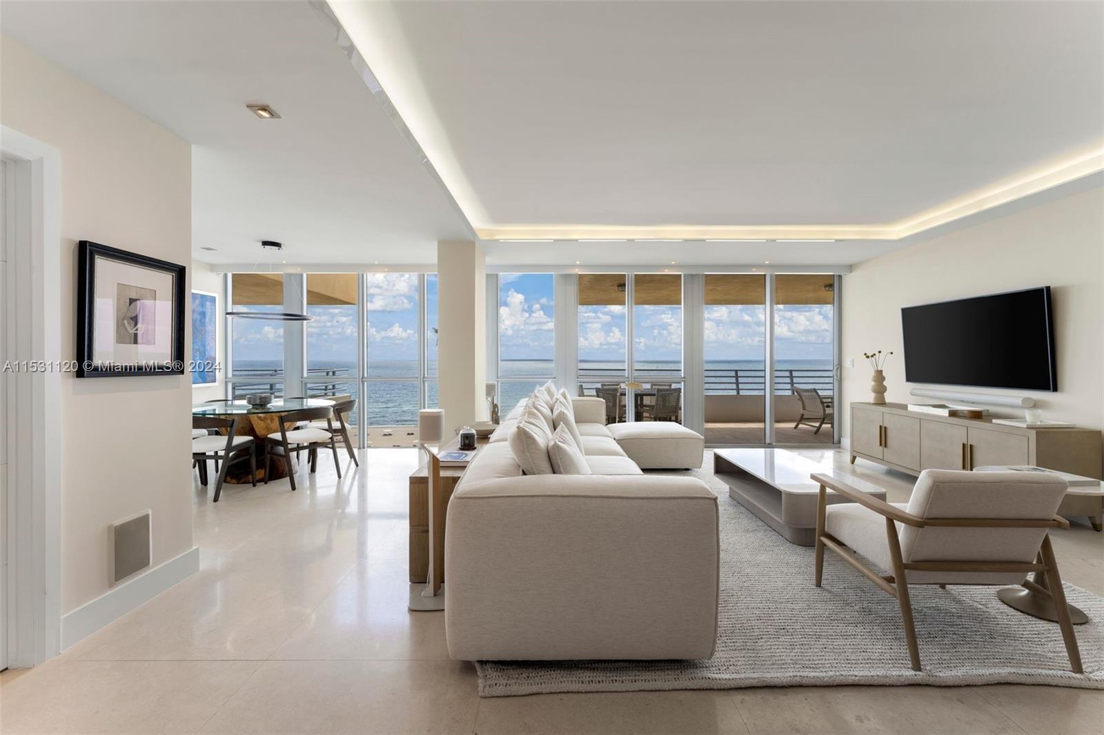 A modern living and dining area features floor-to-ceiling windows with ocean views and tile flooring — 101 Ocean Dr # 907, Miami Beach FL 33139, MIAMI BEACH, FL