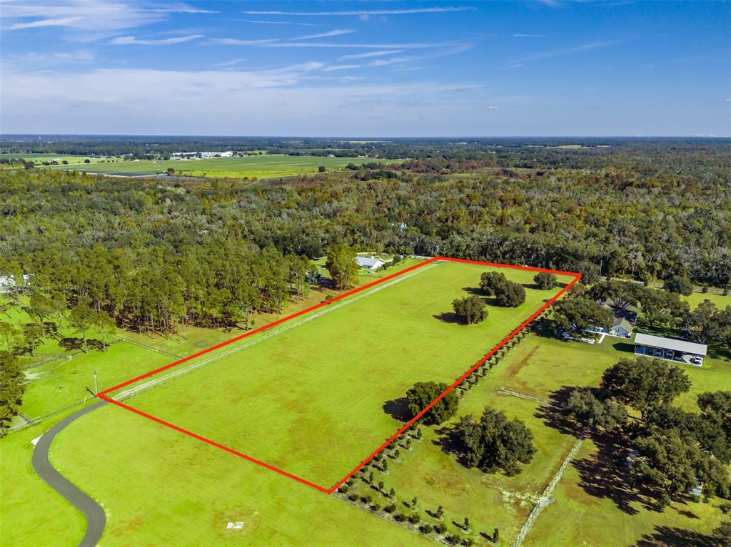 An aerial view shows a large, rectangular grassy lot outlined in red — 3527 POWERLINE ROAD, LITHIA, FL
