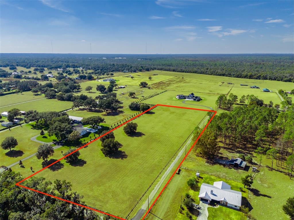 An aerial view shows a large, rectangular grassy lot outlined in red within a rural landscape — 3527 POWERLINE ROAD, LITHIA, FL