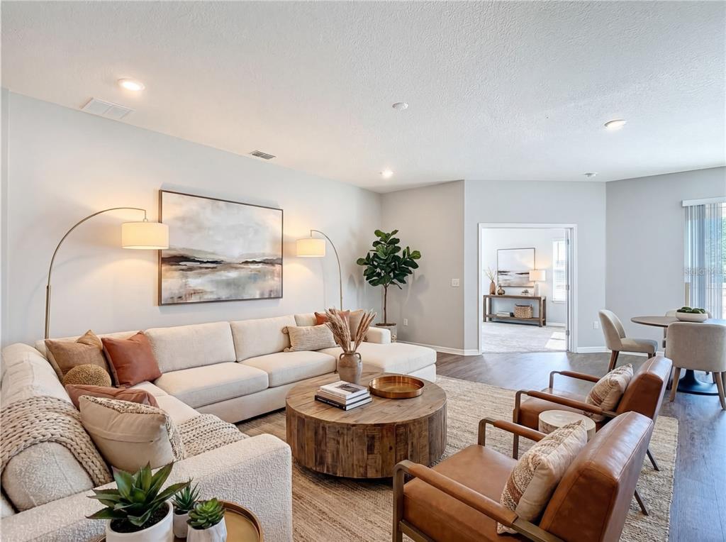 A living room features a large sectional sofa, two leather armchairs, and a round wooden table — 840 SYDNEY STREET, DAVENPORT, FL