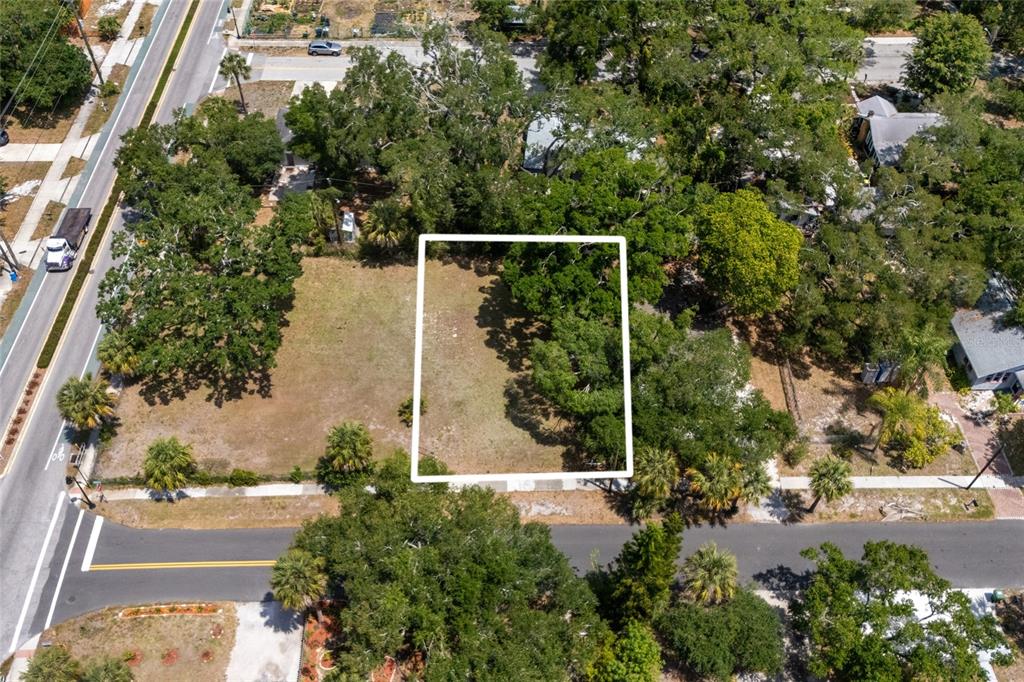 An aerial view shows a rectangular vacant lot outlined in white within a wooded neighborhood — 1207 34TH STREET, SARASOTA, FL