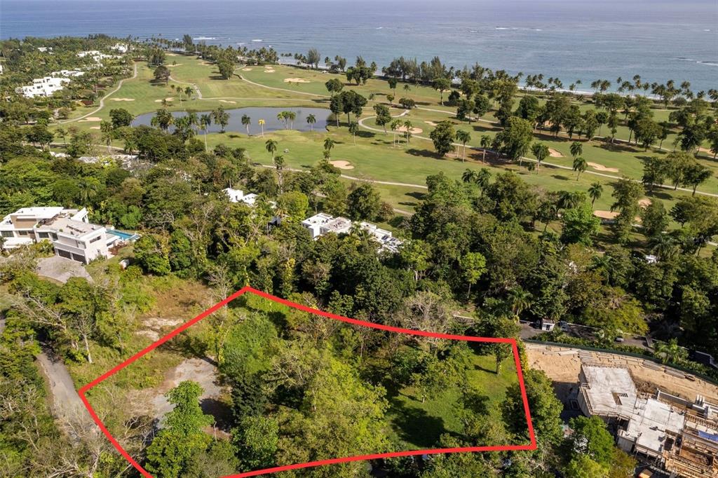 An aerial view shows a vacant, tree-covered lot outlined in red near a golf course — #8 VILLA DORADO ESTATES, DORADO, PR