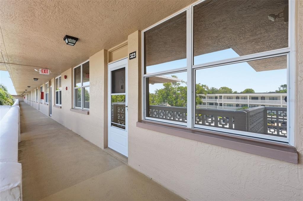 An exterior walkway leads to the entrance of unit 323 with a white storm door — 4915 BAY STREET NE UNIT 323, ST PETERSBURG, FL