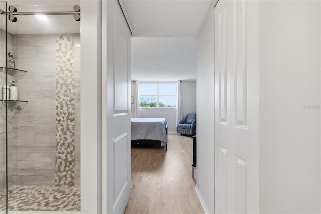 A view from a tiled shower area looking through a doorway into a bedroom — 4915 BAY STREET NE UNIT 323, ST PETERSBURG, FL