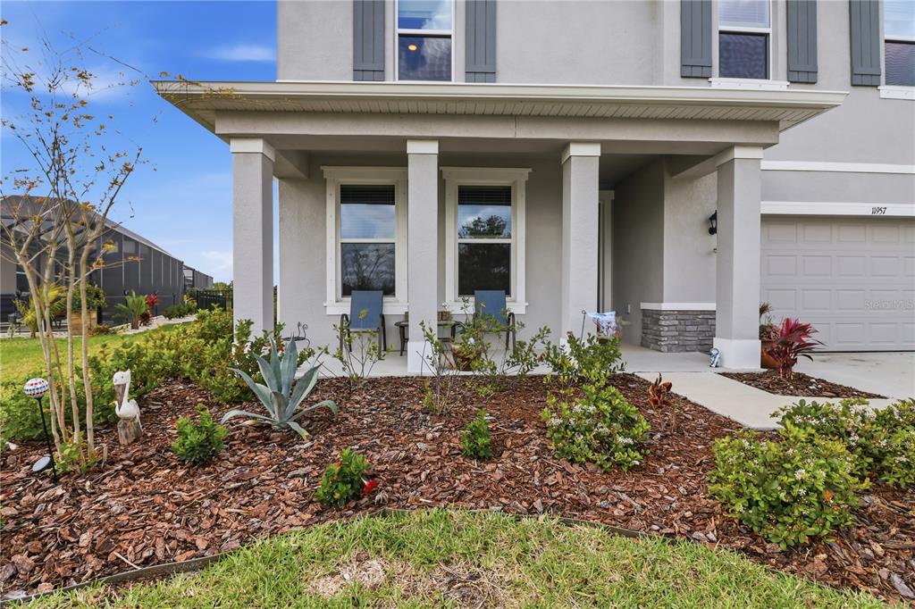 A front view of a two-story house with a covered porch and a garage — 11957 KINGSLEY TRAIL, PARRISH, FL