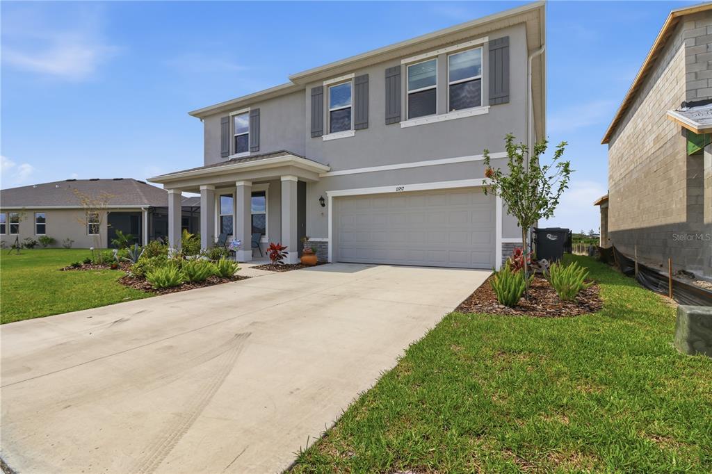 A two-story suburban house with a gray exterior, a two-car garage, and a concrete driveway — 11957 KINGSLEY TRAIL, PARRISH, FL