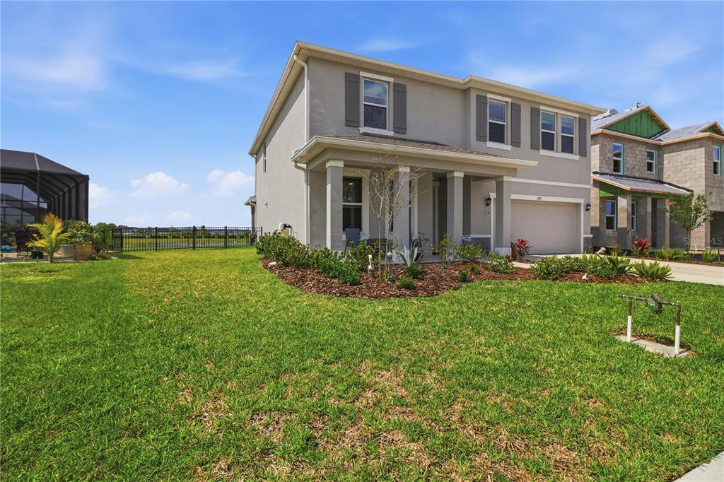 A two-story suburban house with a gray stucco exterior and a front-facing garage — 11957 KINGSLEY TRAIL, PARRISH, FL