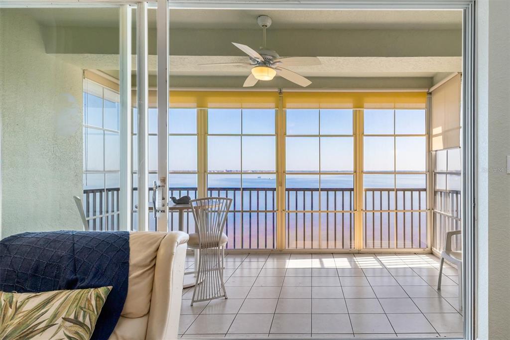 A sunroom with tile floors, a ceiling fan, and large windows overlooking a body of water — 200 HARBOR WALK DRIVE UNIT 354, PUNTA GORDA, FL
