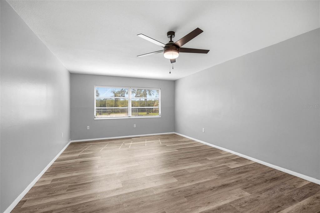 An empty bedroom features gray walls, wood-look flooring, and a ceiling fan — 2900 45TH STREET S UNIT 7, GULFPORT, FL