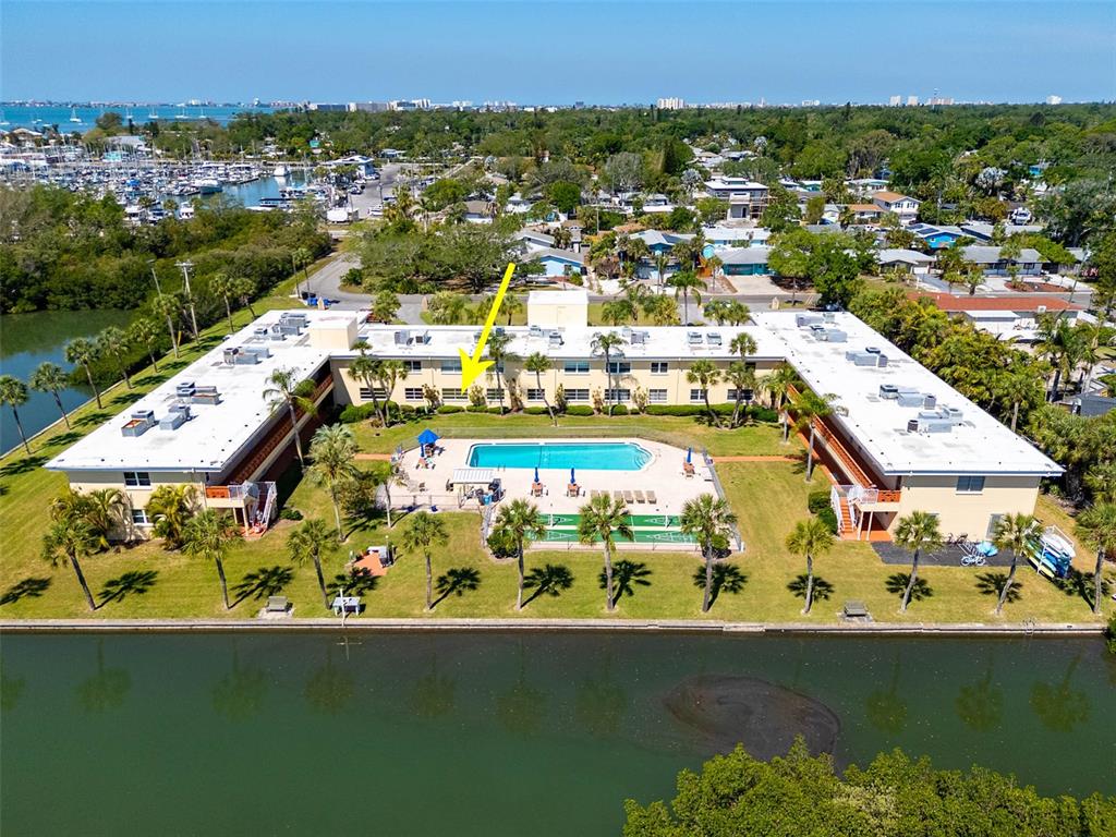 An aerial view shows a U-shaped apartment complex with a central pool and canal frontage — 2900 45TH STREET S UNIT 7, GULFPORT, FL