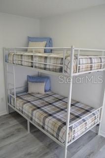 A white metal bunk bed with plaid bedding sits in a room with light flooring — 6516 E 25TH AVENUE, TAMPA, FL