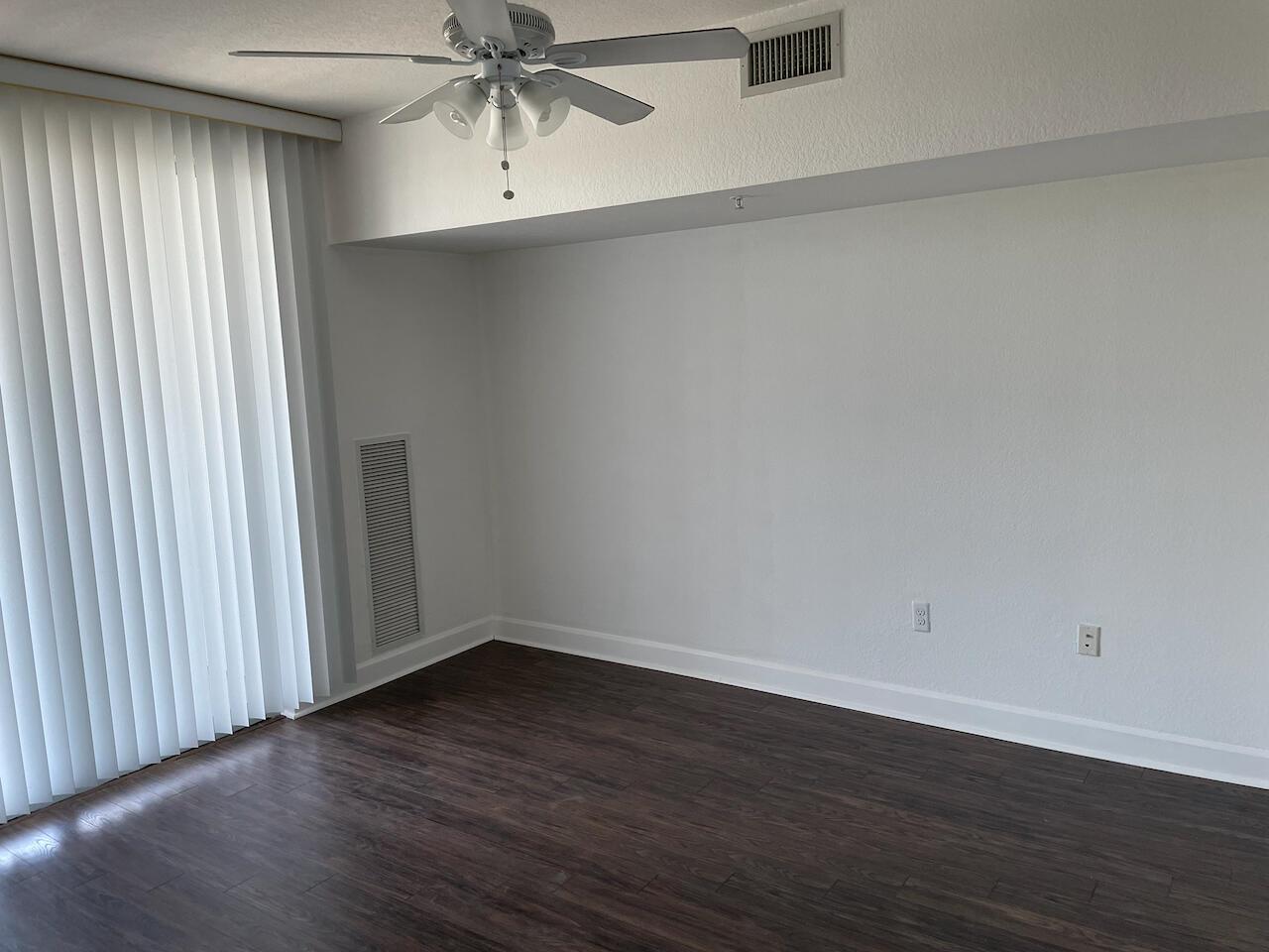 A room with dark wood-look flooring, white walls, a ceiling fan, and vertical blinds — 1830 Radius Drive # 307, Hollywood FL 33020, HOLLYWOOD, FL