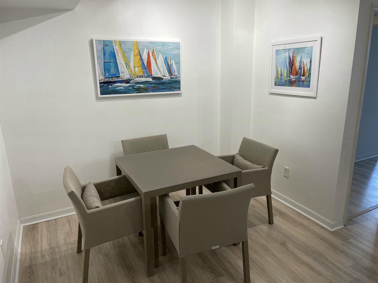 A dining area features a square table with four chairs and two sailboat paintings — 600 S Dixie Highway # 534, West Palm Beach FL 33401, WEST PALM BEACH, FL