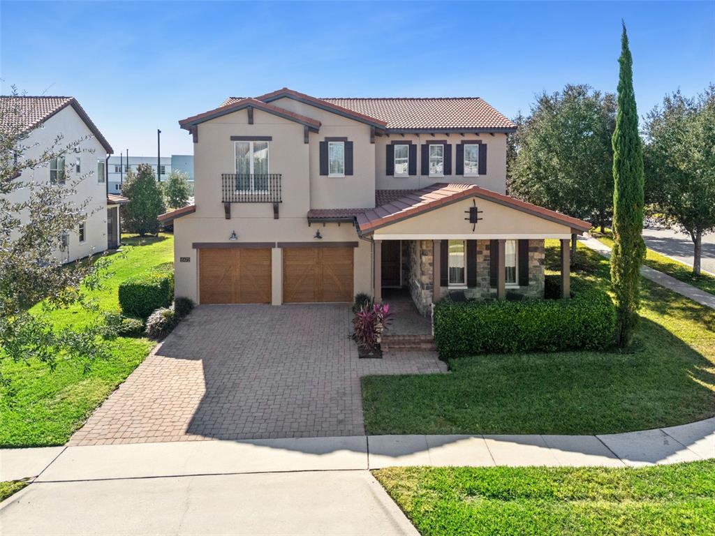 A two-story house with a tiled roof, two-car garage, and a front porch — 15672 SHOREBIRD LANE, WINTER GARDEN, FL