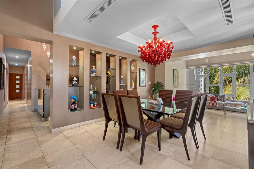 A dining room features a red chandelier, built-in wall niches, and a glass-top table — A31 INGENIERO ROBERTO ARANA STREET, GUAYNABO, PR