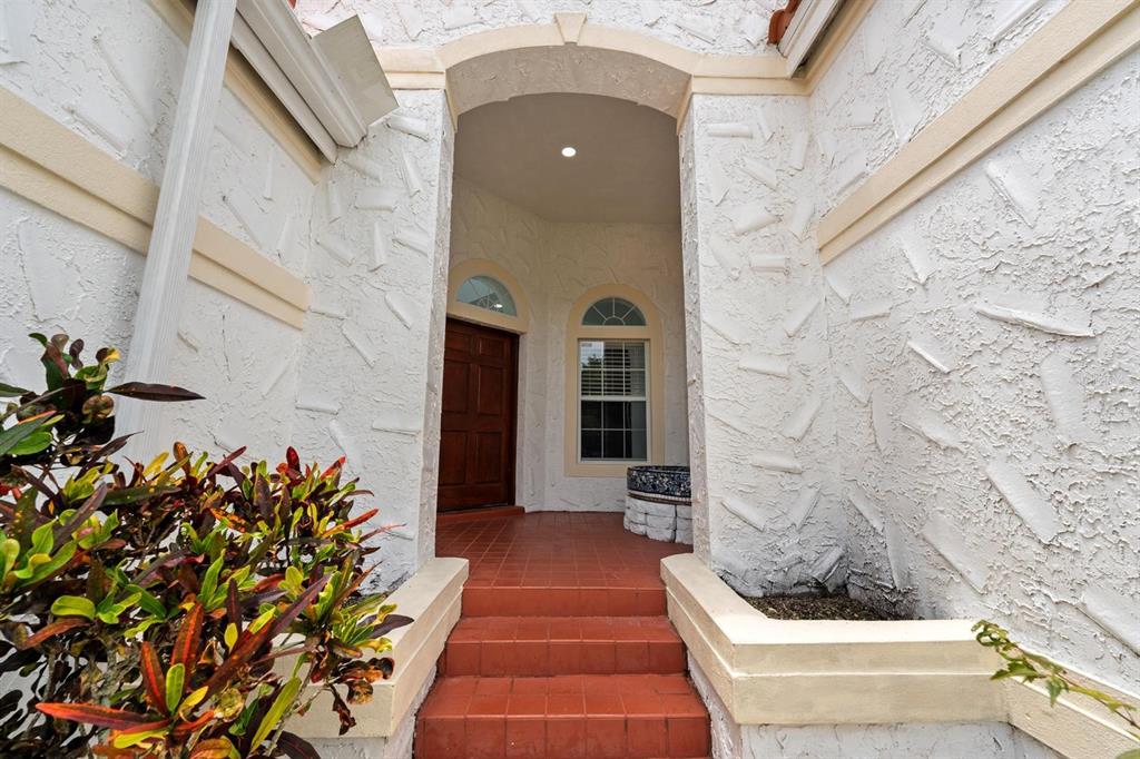 A front entryway features a wooden door, arched windows, and red tile steps — 2985 LA CONCHA DRIVE, CLEARWATER, FL