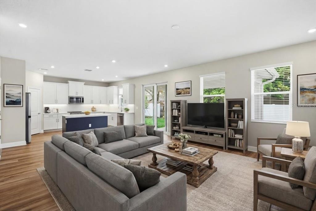 A dining area with a dark table and light chairs opens into a modern white kitchen — 6226 29TH STREET N, ST PETERSBURG, FL