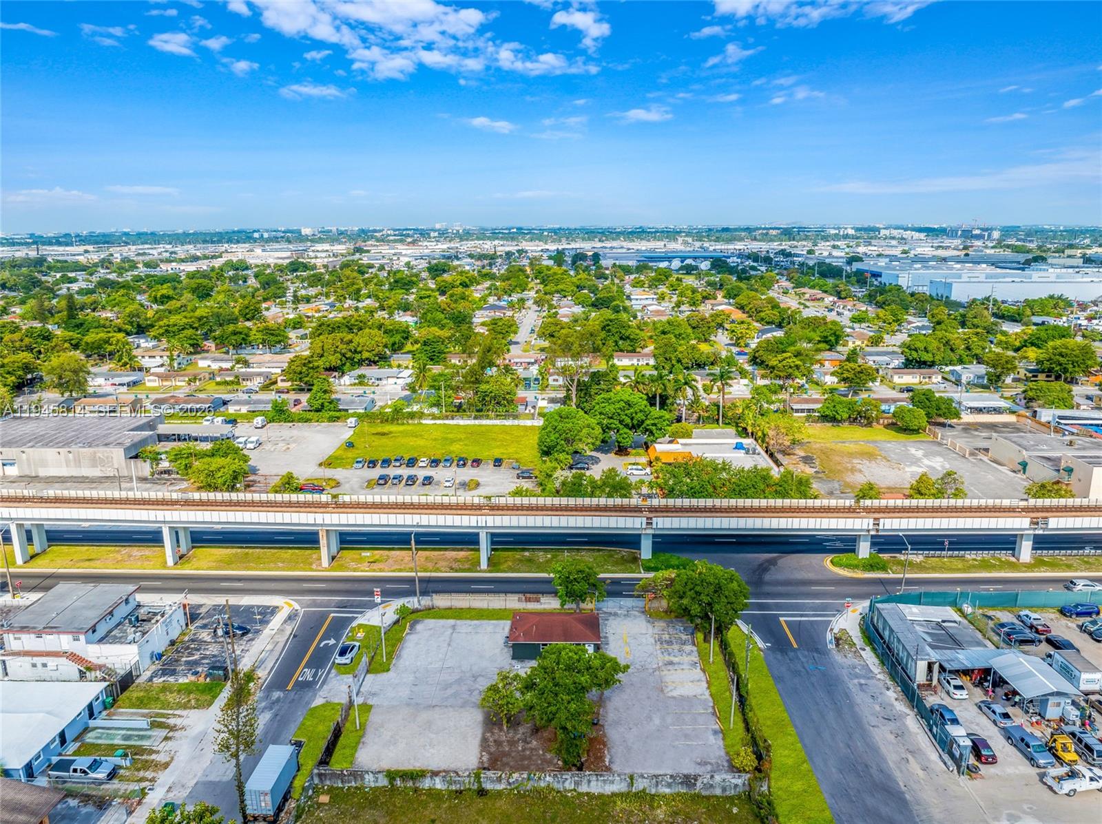 An aerial view shows a small building with a parking lot near an elevated train track — 6801 NW 27th Ave, Miami FL 33147, MIAMI, FL