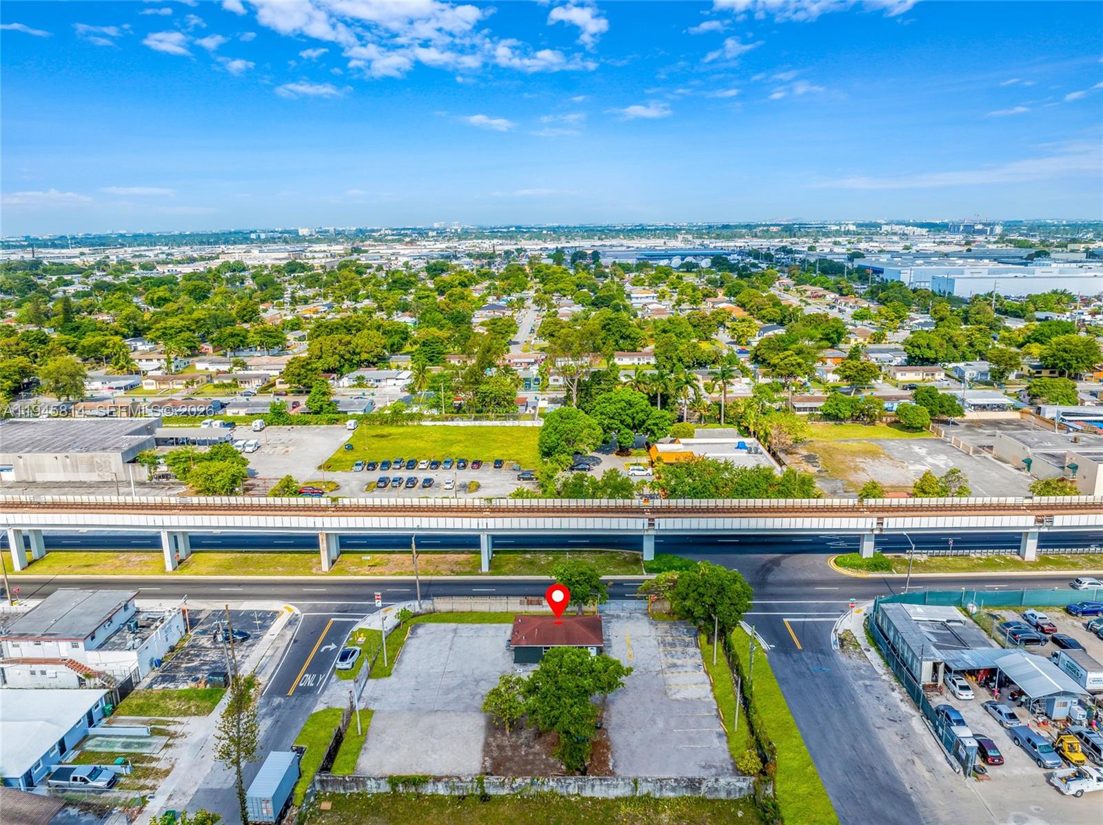 An aerial view shows a small building with a parking lot next to an elevated railway — 6801 NW 27th Ave, Miami FL 33147, MIAMI, FL