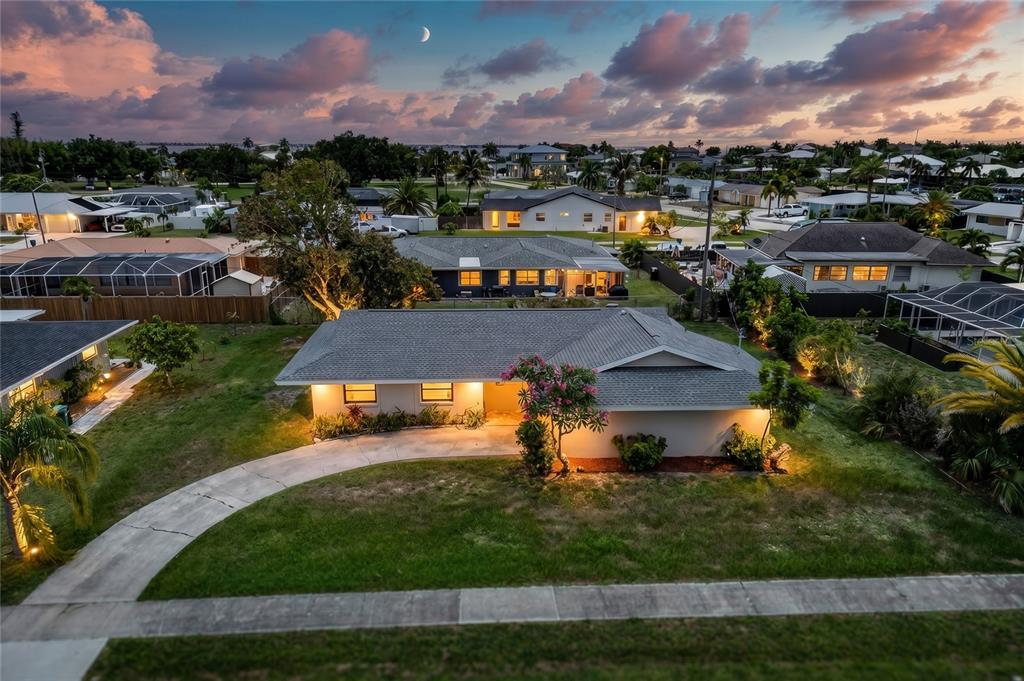 An aerial view of a single-story house with a curved driveway at twilight — 337 COLGAN AVENUE SE, PORT CHARLOTTE, FL