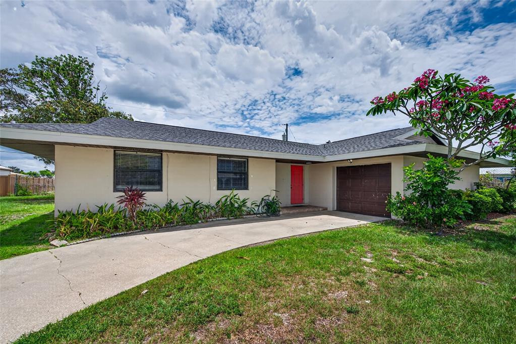 A single-story house with a beige exterior, a red front door, and a brown garage — 337 COLGAN AVENUE SE, PORT CHARLOTTE, FL
