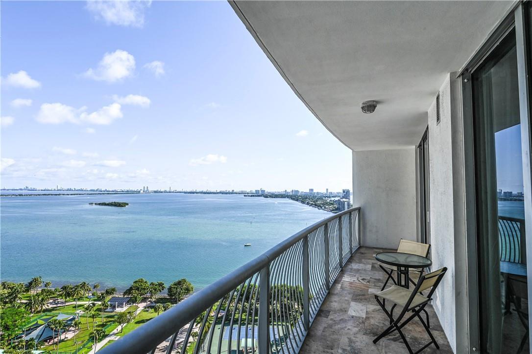 A high-rise balcony with a metal railing overlooks a large bay and a park — 1750 N Bayshore Drive # 2403, Miami FL 33132, MIAMI, FL
