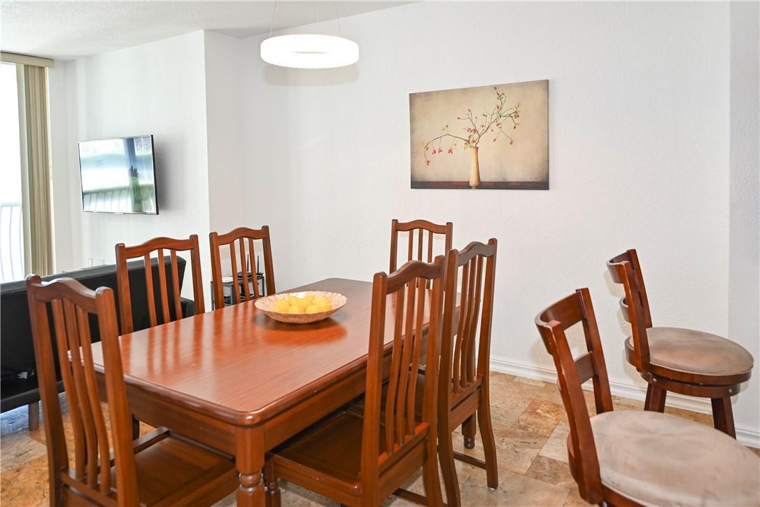 A dining room features a wooden table with chairs, a bowl of lemons, and artwork — 1750 N Bayshore Drive # 2403, Miami FL 33132, MIAMI, FL