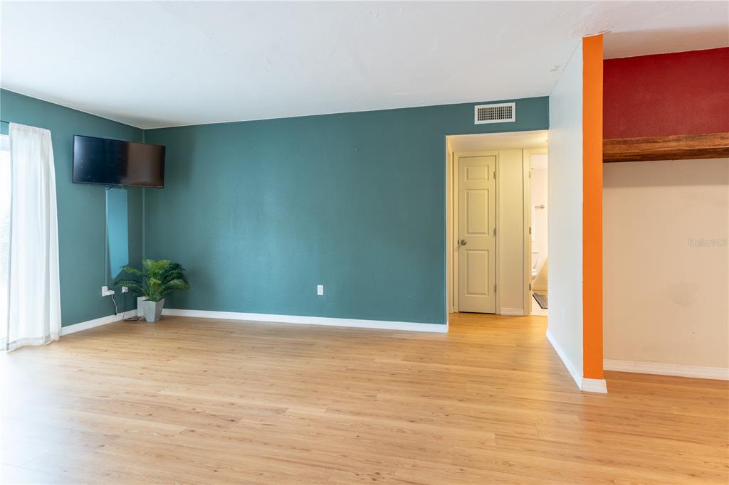 A living room features green walls, light wood-look flooring, and a sliding glass door — 507 NW 39TH ROAD UNIT 132, GAINESVILLE, FL