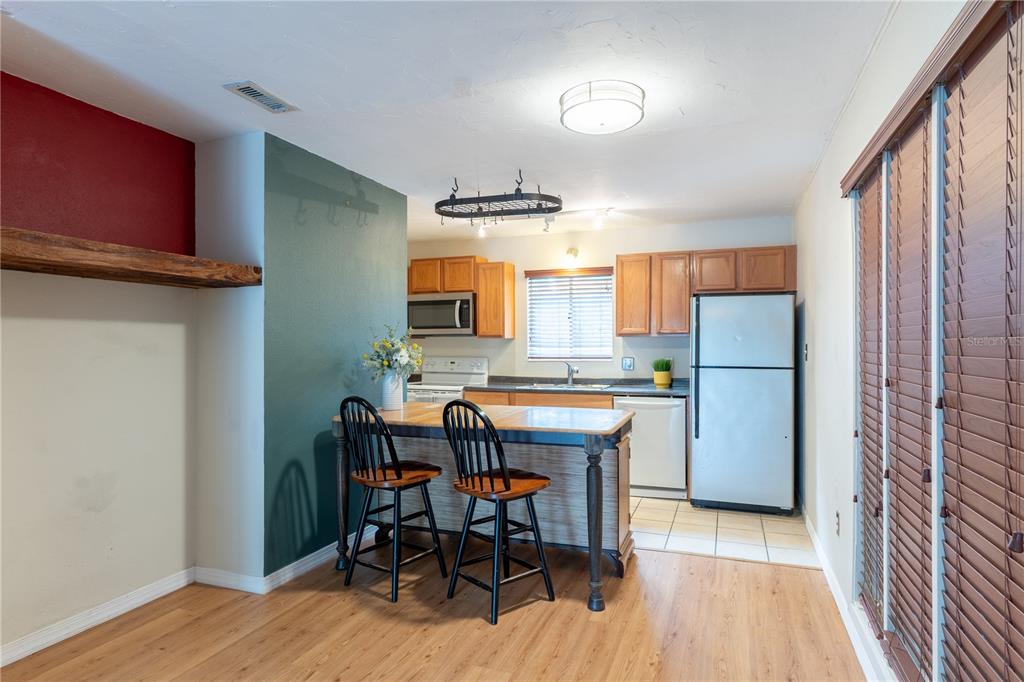 A living room features teal walls, light wood-look flooring, and an orange accent wall — 507 NW 39TH ROAD UNIT 132, GAINESVILLE, FL