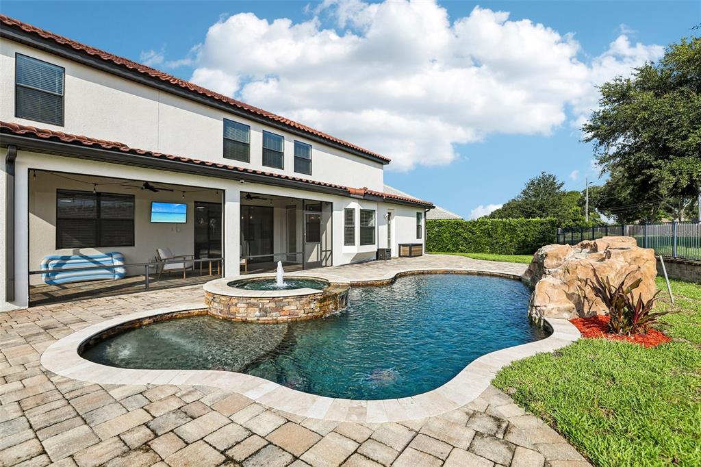 A two-story house with a screened patio, a pool with a fountain, and rock features — 5785 SAYBROOK CIRCLE, SANFORD, FL