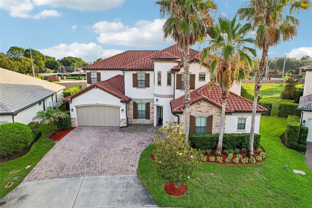 An aerial view of a two-story house with a tile roof, stone facade, and driveway — 5785 SAYBROOK CIRCLE, SANFORD, FL