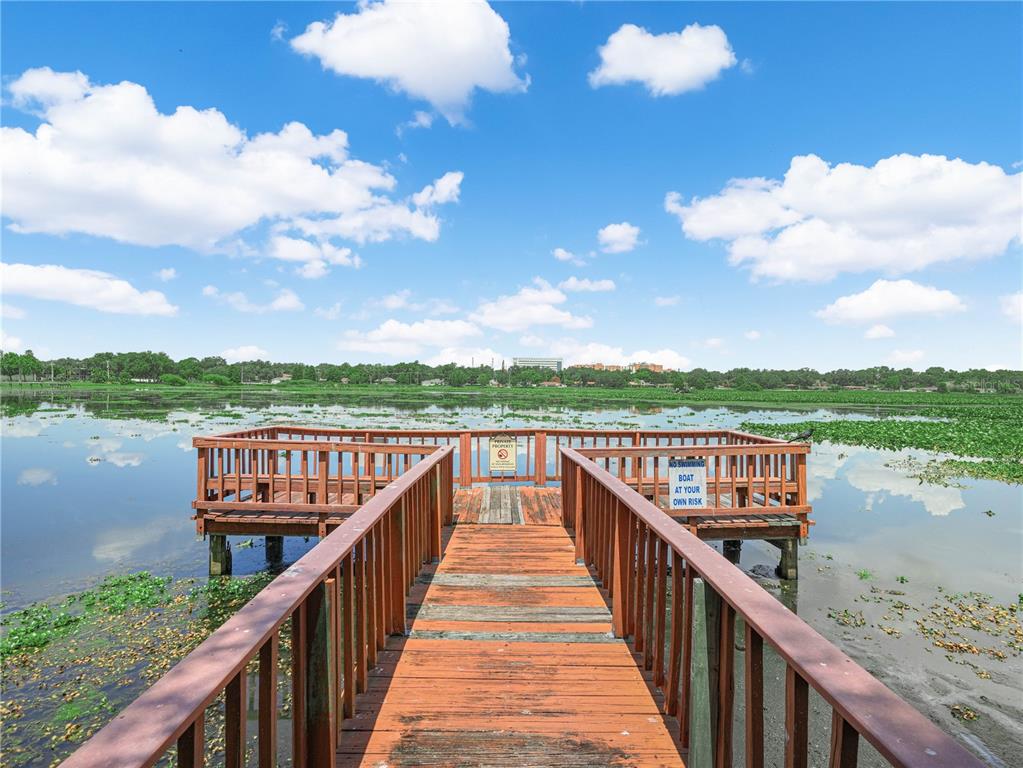 A wooden pier extends over a lake covered in aquatic vegetation under a blue sky — 1130 N LAKE PARKER AVENUE UNIT A308, LAKELAND, FL